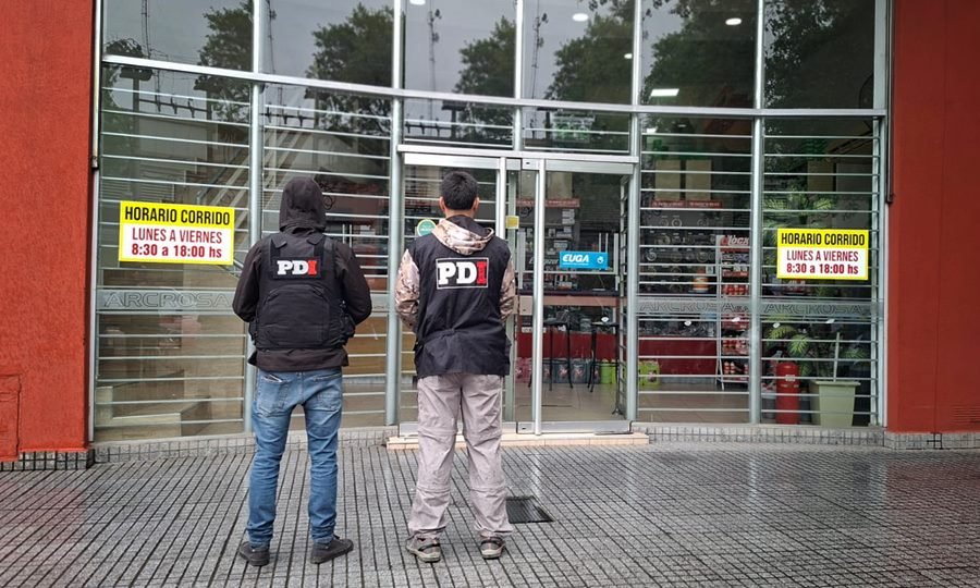 Personal de la PDI inspecciona una de las firmas allanadas en el marco de una causa por presunta defraudación a la administración pública.