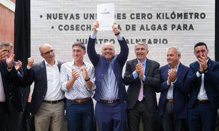 Momento histórico: Elvio Cotterli sostiene las escrituras que devuelven a Laguna Paiva las tierras del ex Belgrano, acompañado por ministros y legisladores provinciales.