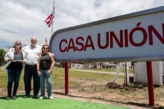 Luis Spahn junto a las hijas del fallecido expresidente Ángel Malvicino frente al cartel de ingreso del predio durante la presentación oficial de Casa Unión.