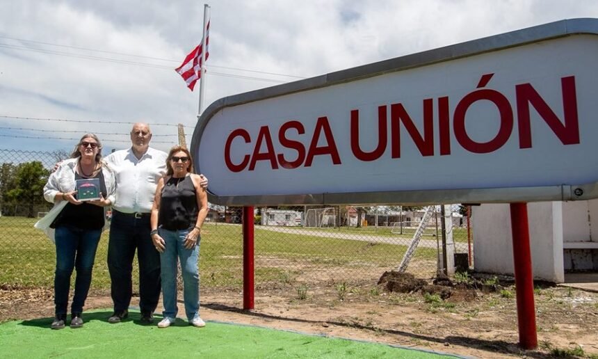 Luis Spahn junto a las hijas del fallecido expresidente Ángel Malvicino frente al cartel de ingreso del predio durante la presentación oficial de Casa Unión.