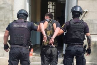 Personal policial traslada al detenido luego del operativo realizado en el Barrio Centenario de la ciudad de Santa Fe.