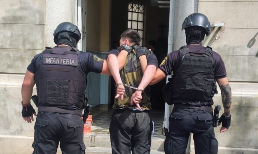 Personal policial traslada al detenido luego del operativo realizado en el Barrio Centenario de la ciudad de Santa Fe.