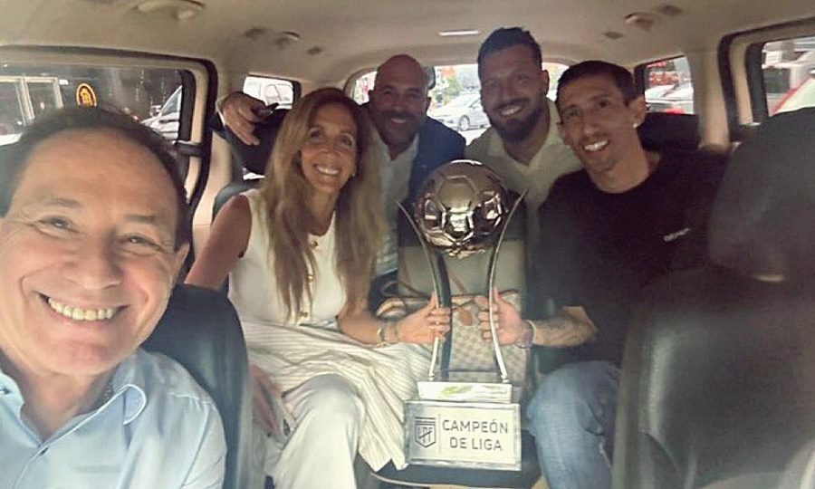 Integrantes del plantel y la dirigencia posan con el trofeo de campeón de Liga durante el viaje de regreso, tras la oficialización del título.