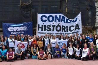 Docentes universitarios y representantes gremiales durante una jornada de protesta frente a una universidad pública.