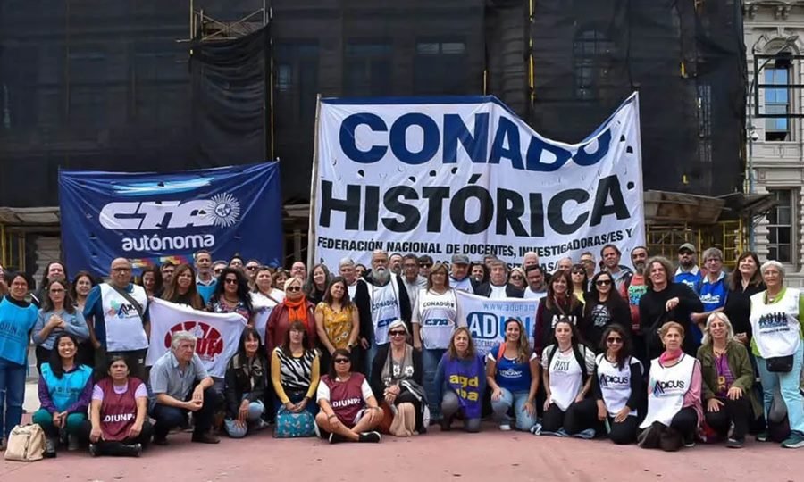Docentes universitarios y representantes gremiales durante una jornada de protesta frente a una universidad pública.
