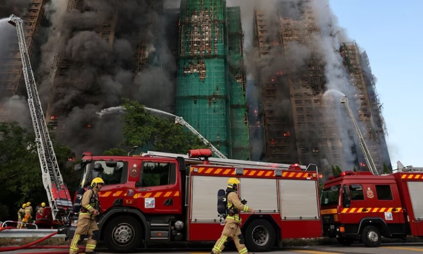 Bomberos trabajan entre el humo y los restos del andamiaje colapsado en el complejo afectado de Tai Po.