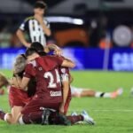 Plantel de Lanús en festejo de título internacional, levantando el trofeo en una final histórica.