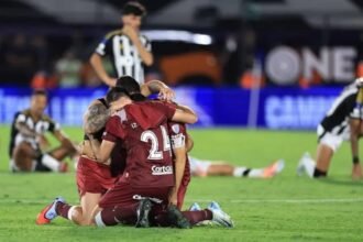 Plantel de Lanús en festejo de título internacional, levantando el trofeo en una final histórica.