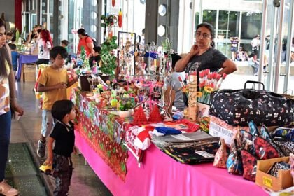 Familias recorren los stands de emprendedores y artesanos durante la feria navideña en el Centro Cultural Municipal.
