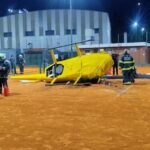 Bomberos y personal de emergencia trabajan sobre la cancha de tenis instantes después de la caída del helicóptero.