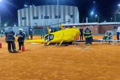 Bomberos y personal de emergencia trabajan sobre la cancha de tenis instantes después de la caída del helicóptero.