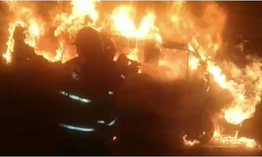 Bomberos trabajan en el control de un incendio de gran magnitud en un predio vehicular.