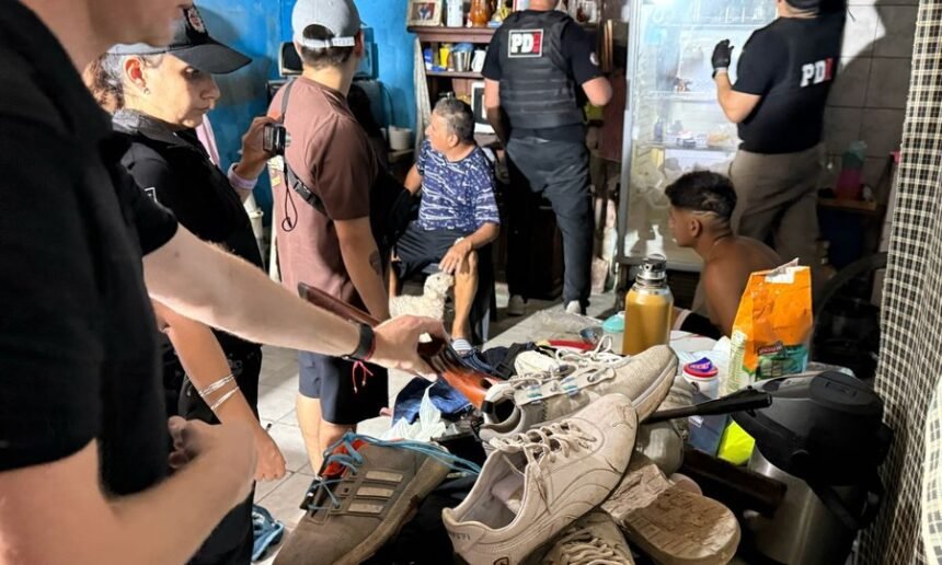 Personal policial ingresa a una vivienda durante uno de los 31 allanamientos simultáneos realizados en barrios del noroeste de la ciudad de Santa Fe.