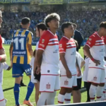 Jugadores de Estudiantes se giran de espaldas durante el ingreso de Rosario Central al campo de juego, en el episodio que derivó en sanciones disciplinarias para los futbolistas involucrados.