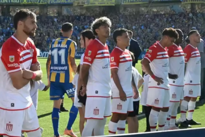 Jugadores de Estudiantes se giran de espaldas durante el ingreso de Rosario Central al campo de juego, en el episodio que derivó en sanciones disciplinarias para los futbolistas involucrados.