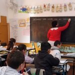 Docente dictando clases frente a sus alumnos en un aula de escuela pública. Foto de archivo.