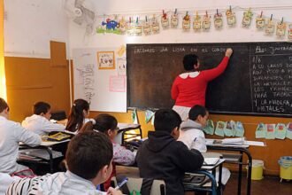 Docente dictando clases frente a sus alumnos en un aula de escuela pública. Foto de archivo.