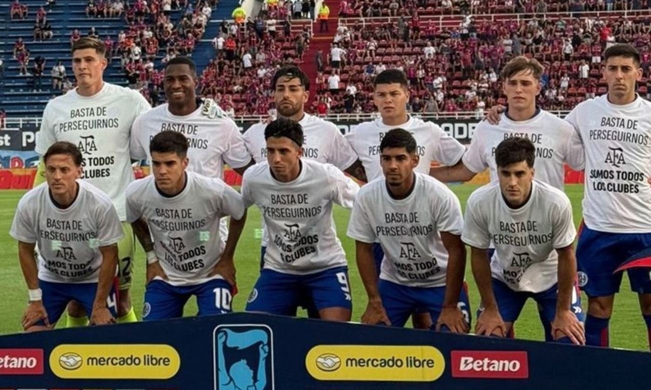 Los jugadores de San Lorenzo e Instituto exhiben una camiseta en respaldo a la AFA antes del inicio del partido en el Nuevo Gasómetro.
