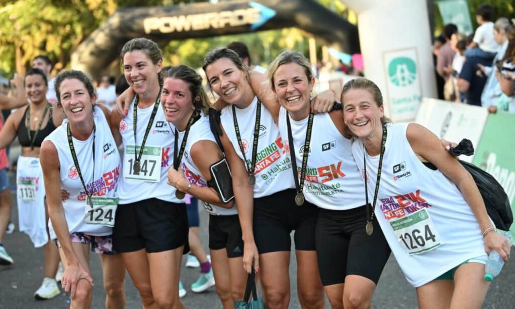 Corredores cruzan la meta y celebran su llegada como finishers de la Media Maratón de Santa Fe, tras completar el circuito por la Costanera de la ciudad.