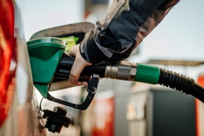 Surtidor de combustible en estación de servicio con actualización de precios. Imagen de archivo.