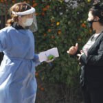 Personas aplicando medidas de prevención sanitaria, como el uso de barbijo y alcohol en gel, durante la pandemia de Covid-19. Foto de archivo.
