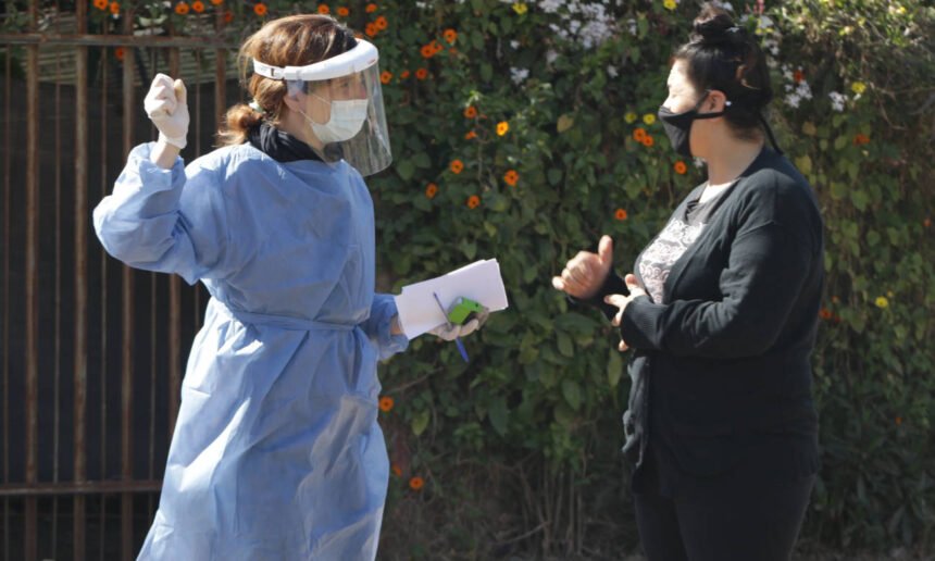 Personas aplicando medidas de prevención sanitaria, como el uso de barbijo y alcohol en gel, durante la pandemia de Covid-19. Foto de archivo.