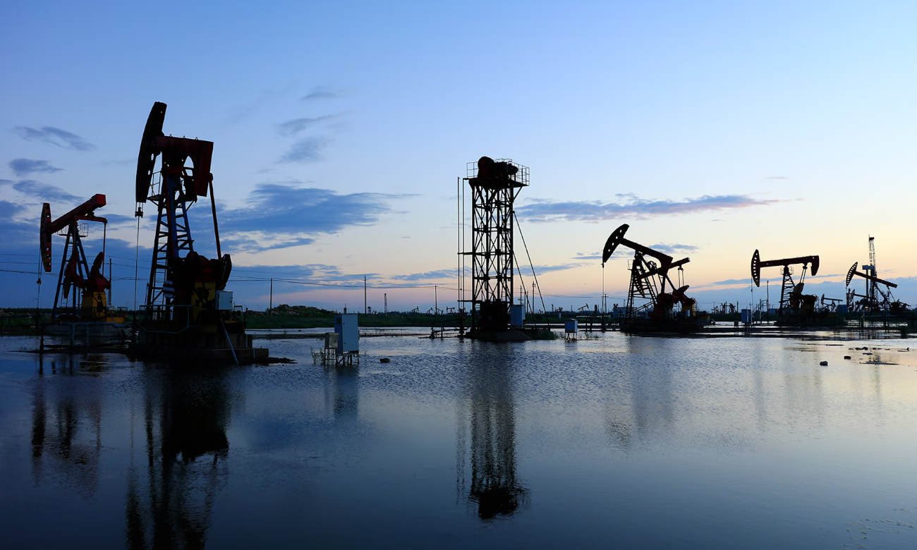Vista general de un yacimiento petrolero en plena operación de extracción, con equipos trabajando de forma continua. Foto de archivo.