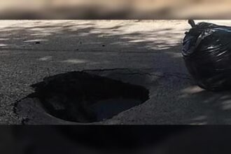 Socavón de gran tamaño en una calle urbana tras el hundimiento del pavimento.