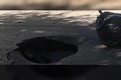 Socavón de gran tamaño en una calle urbana tras el hundimiento del pavimento.