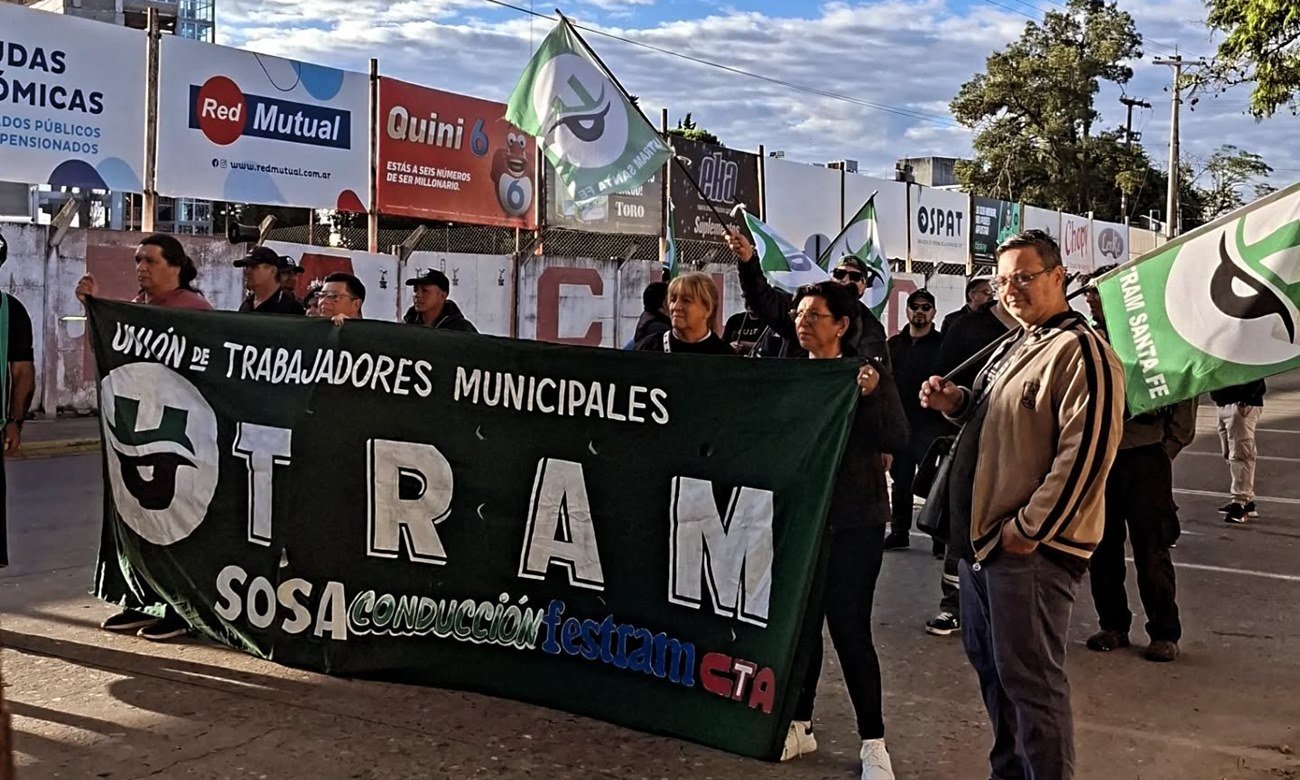 Protesta de trabajadores municipales con corte de tránsito y reclamos laborales en una avenida urbana.