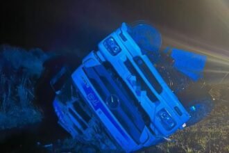 Camión de carga volcado sobre la banquina de una autopista tras un accidente, con intervención de equipos de emergencia. Foto de archivo.