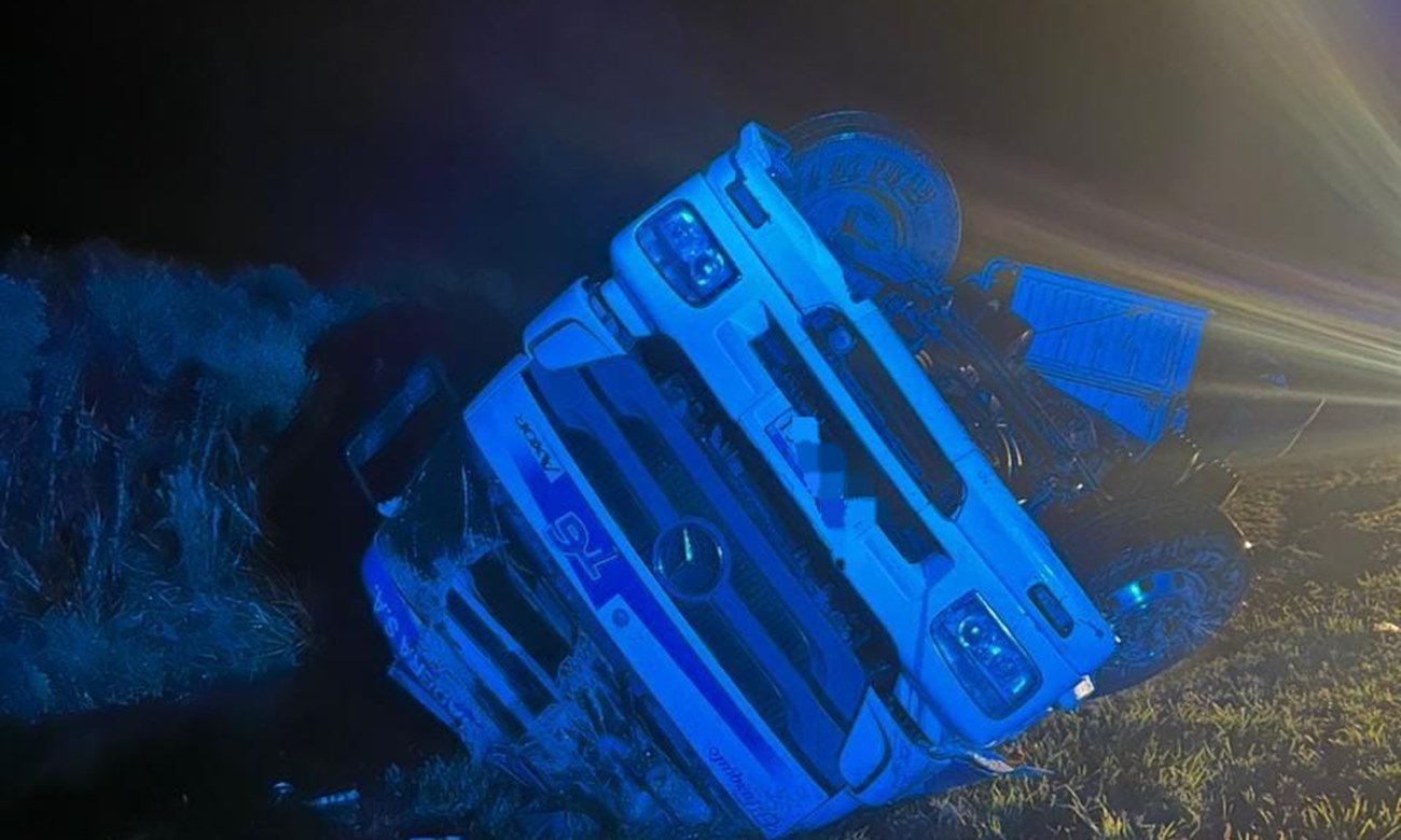 Camión de carga volcado sobre la banquina de una autopista tras un accidente, con intervención de equipos de emergencia. Foto de archivo.