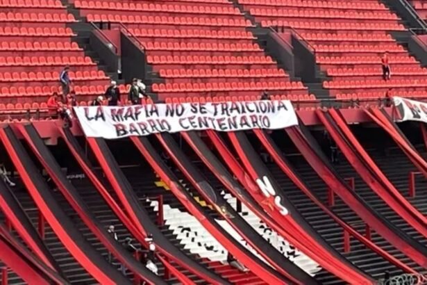 Bandera con mensaje intimidante desplegada en la cabecera norte del estadio de Club Atlético Colón durante un partido oficial.