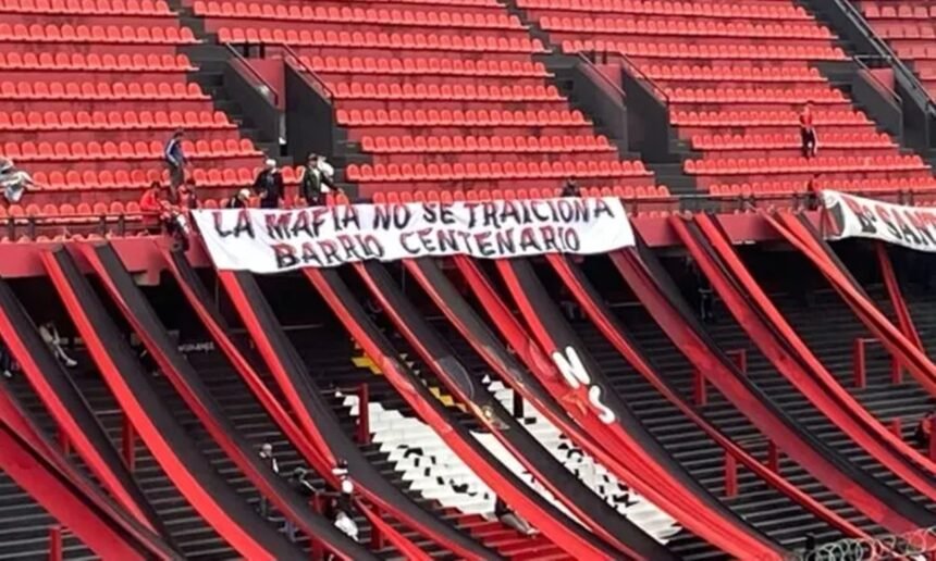 Bandera con mensaje intimidante desplegada en la cabecera norte del estadio de Club Atlético Colón durante un partido oficial.