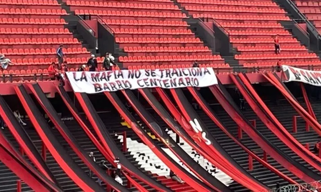 Bandera con mensaje intimidante desplegada en la cabecera norte del estadio de Club Atlético Colón durante un partido oficial.