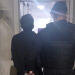Joven de 21 años detenido por intento de robo en una escuela, escoltado por efectivos policiales en sede de la Comisaría.