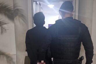 Joven de 21 años detenido por intento de robo en una escuela, escoltado por efectivos policiales en sede de la Comisaría.