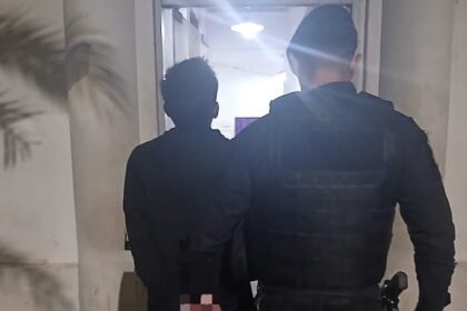 Joven de 21 años detenido por intento de robo en una escuela, escoltado por efectivos policiales en sede de la Comisaría.