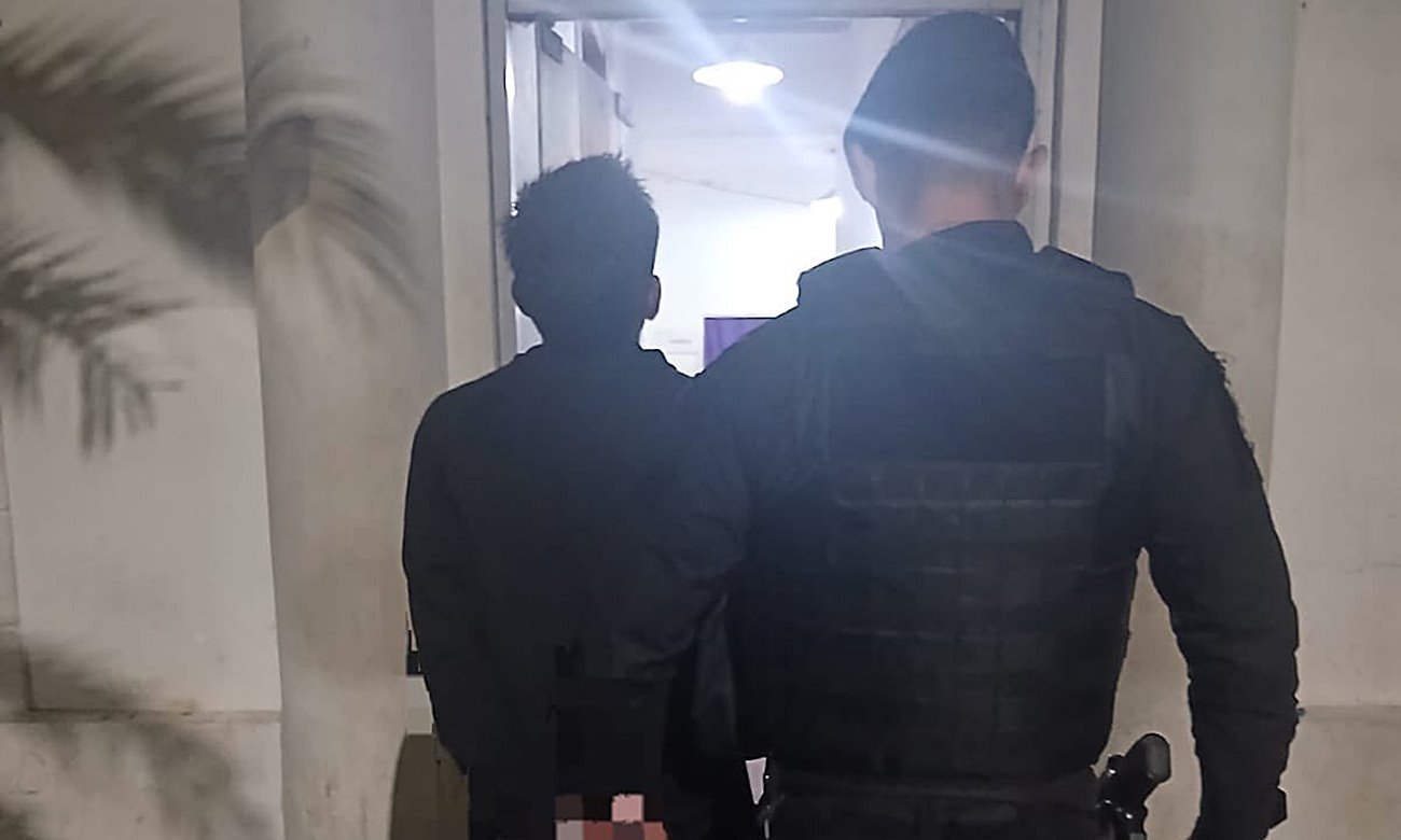 Joven de 21 años detenido por intento de robo en una escuela, escoltado por efectivos policiales en sede de la Comisaría.