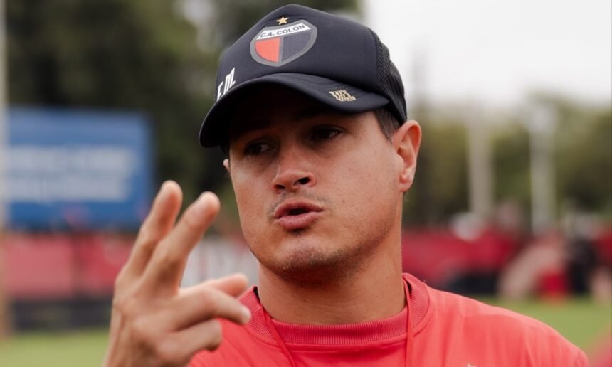Ezequiel Medrán dirigiendo un entrenamiento de Colón en el campo de juego, dando indicaciones a sus jugadores.