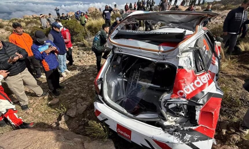 Auto de rally tras un despiste durante una competencia en caminos de montaña, con presencia de equipos de asistencia.
