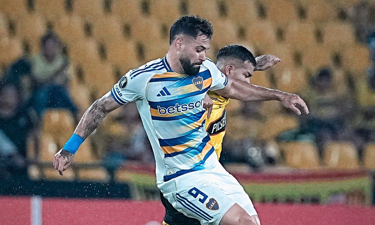 Jugadores de Boca Juniors disputan un partido bajo intensa lluvia en un campo de juego afectado por las condiciones climáticas. Foto de archivo.