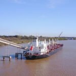 Buque de carga amarrado en una terminal portuaria mientras se realizan controles y tareas operativas. Foto de archivo.