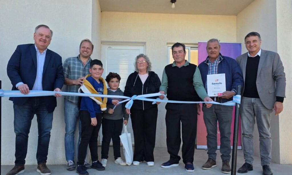Autoridades provinciales y familias beneficiarias durante la entrega de viviendas sociales en localidades del departamento San Cristóbal.