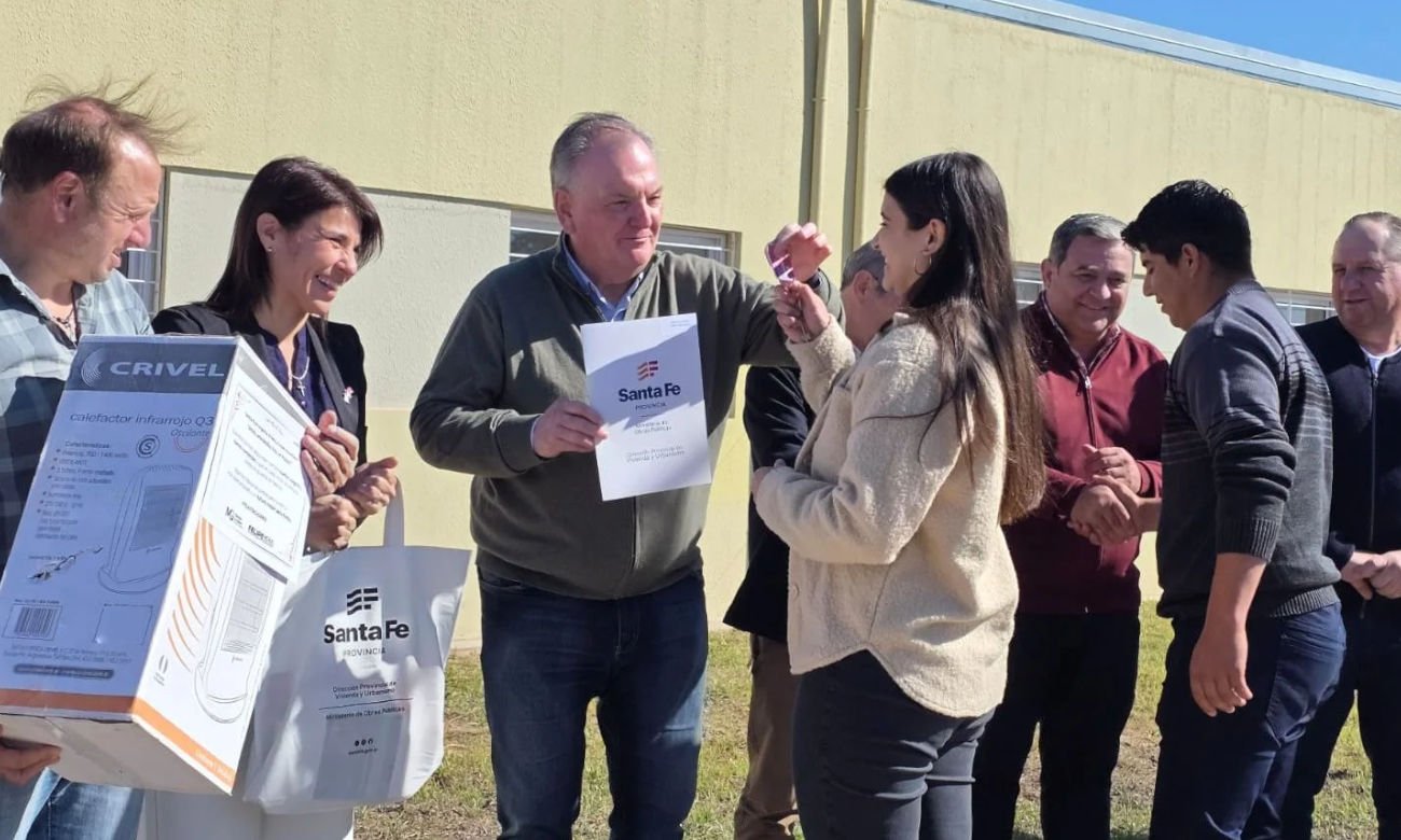 Felipe Michlig entrega las llaves de una nueva vivienda a una de las familias beneficiarias durante el acto realizado en Hersilia.