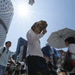 Personas se protegen del calor extremo durante una jornada de altas temperaturas en Japón. Las olas de calor afectan la vida cotidiana y aumentan los riesgos para la salud. Foto de archivo.