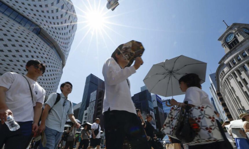 Personas se protegen del calor extremo durante una jornada de altas temperaturas en Japón. Las olas de calor afectan la vida cotidiana y aumentan los riesgos para la salud. Foto de archivo.