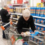 Consumidores consultan precios y comparan productos durante sus compras en un supermercado. Foto de archivo.