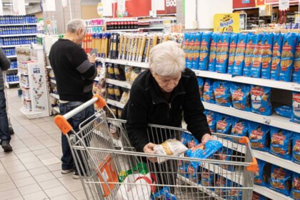 Consumidores consultan precios y comparan productos durante sus compras en un supermercado. Foto de archivo.