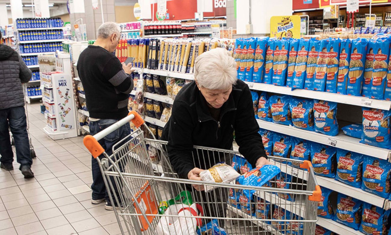 Consumidores consultan precios y comparan productos durante sus compras en un supermercado. Foto de archivo.